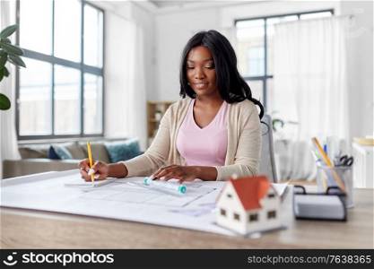 architecture, building, construction and real estate concept - happy smiling african american female architect with blueprint, ruler and living house model on table working at home office. female architect with house model and blueprint