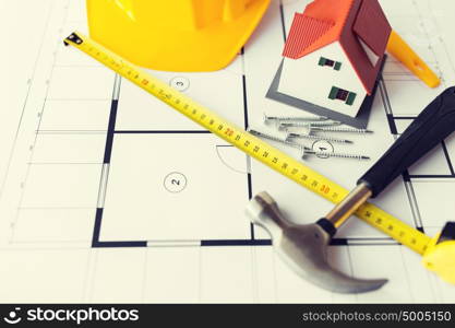 architecture, building, construction, real estate and home concept - close up of living house model on blueprint with repair tools. close up of house blueprint with building tools