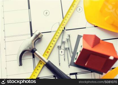 architecture, building, construction, real estate and home concept - close up of living house model on blueprint with repair tools. close up of house blueprint with building tools