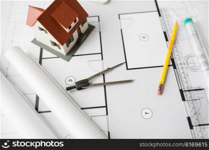 architecture, building, construction, real estate and home concept - close up of blueprint with living house model and tools
