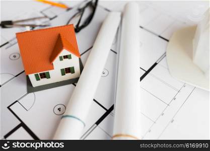 architecture, building, construction, real estate and home concept - close up of living house model on blueprint