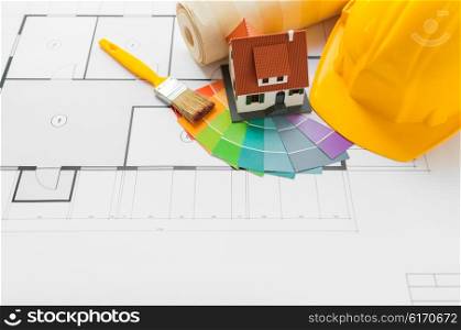 architecture, building, construction, real estate and home concept - close up of living house model on blueprint with repair tools