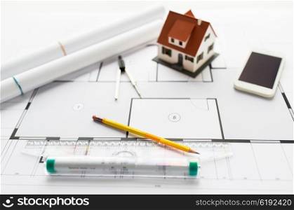 architecture, building, construction, real estate and home concept - close up of blueprint with living house model and tools