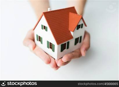 architecture, building, mortgage, real estate and people concept - close up of architect hands holding living house model