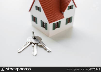 architecture, building, mortgage, real estate and property concept - close up of home model and house keys