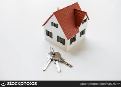 architecture, building, mortgage, real estate and property concept - close up of home model and house keys