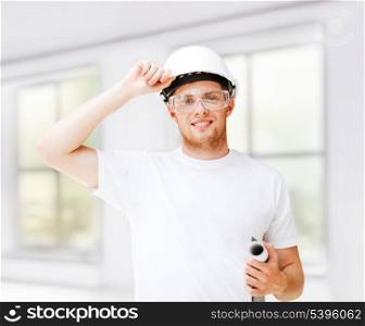 architecture concept - male architect in helmet with blueprint and safety glasses