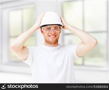 architecture concept - male architect in helmet with safety glasses