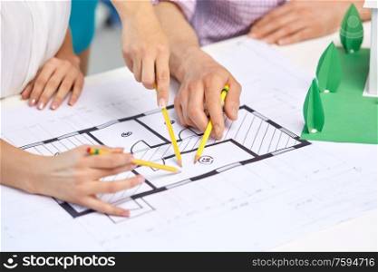 architecture, construction and people concept - team of architects or designers with project blueprint and building layout working at office. creative team building project blueprint at office