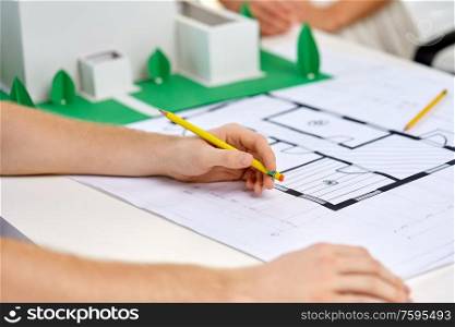 architecture, construction and people concept - team of architects or designers with project blueprint and building layout working at office. creative team building project blueprint at office