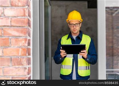 architecture, construction business and building concept - male architect in helmet and safety west with tablet pc computer in window. architect in helmet and safety west with tablet pc