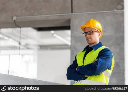architecture, construction business and building concept - male architect or builder in helmet and safety west at office. male builder in helmet and safety west at office
