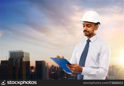 architecture, construction business and building - indian architect or businessman in helmet with clipboard writing over sunset in tokyo city background. architect in helmet with clipboard in tokyo