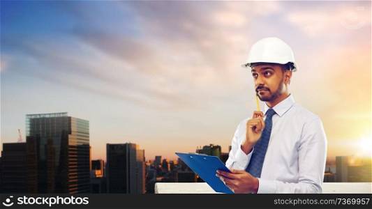 architecture, construction business and building - indian architect or businessman in helmet with clipboard thinking over grey background. architect or businessman in helmet with clipboard