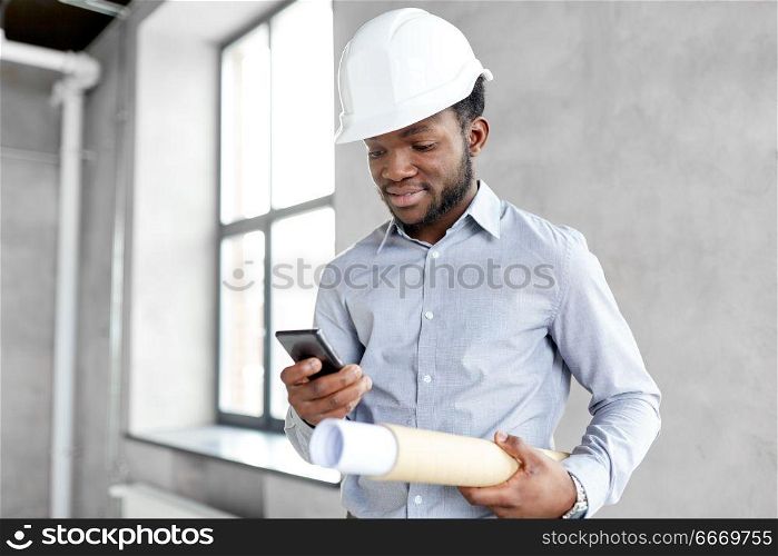 architecture, construction business and people concept - african american architect in helmet with blueprint and smartphone. architect in helmet with blueprint and smartphone. architect in helmet with blueprint and smartphone