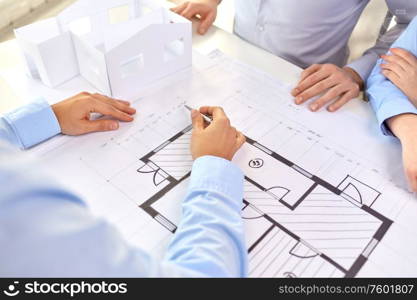 architecture, construction business and people concept - close up of architects discussing blueprint of house project at office. close up of architects with blueprint at office