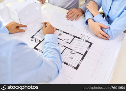 architecture, construction business and people concept - close up of architects discussing blueprint of house project at office. close up of architects with blueprint at office