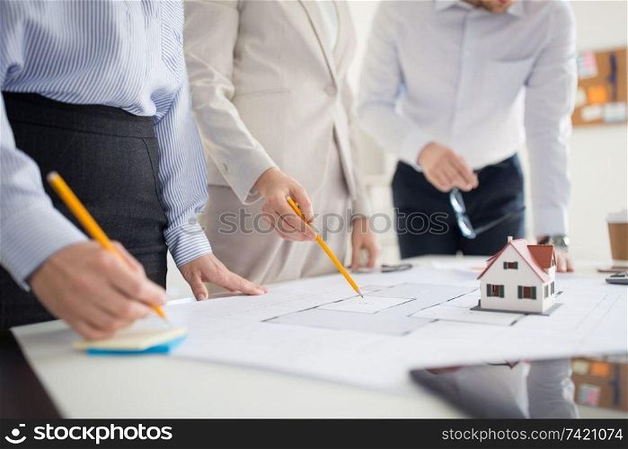 architecture, construction business and people concept - close up of architects with blueprint discussing house project at office. close up of architects discussing house project