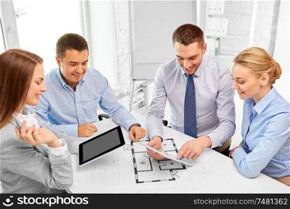 architecture, construction business and people concept - happy team of architects discussing blueprint at office. happy business team discussing blueprint at office