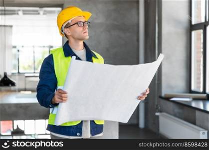 architecture, construction business and people concept - male architect in helmet with blueprint at office. male architect in helmet with blueprint at office