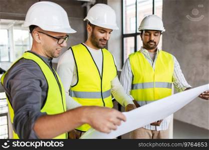 architecture, construction business and people concept - male architects in helmets with blueprint working at office. architects in helmets with blueprint at office
