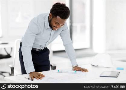 architecture, construction business and people concept - smiling african american architect with blueprint working at office. smiling african architect with blueprint at office. smiling african architect with blueprint at office