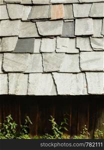 Architecture details concept. Detailed closeup of dark grey stone rock roof tiles.. Closeup of dark grey stone roof tiles