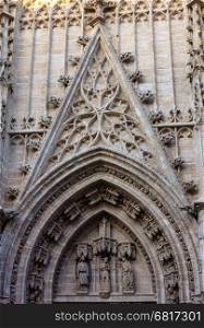 Architecture details over entrance door of Seville Cathedral (or Cathedral of Saint Mary of the See). Build in 1402-1506.