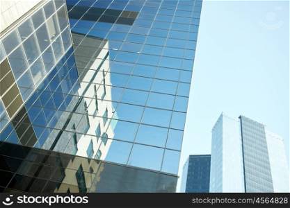 architecture, exterior, business, real estate and construction concept - close up of office building or skyscraper and sky