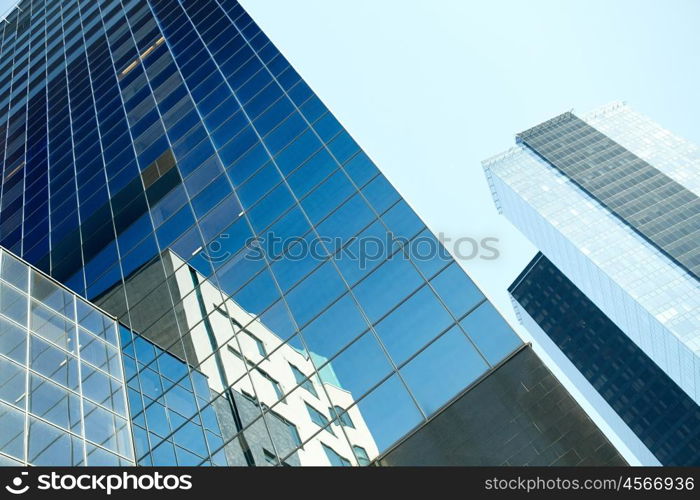 architecture, exterior, business, real estate and construction concept - close up of office building or skyscraper and sky