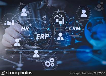 Architecture of ERP (Enterprise Resource Planning) system with connections between business intelligence (BI), production, CRM modules and HR diagram.businessman hand working with modern digital tablet computer.