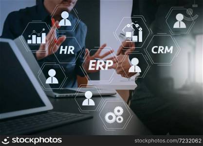 Architecture of ERP (Enterprise Resource Planning) system with connections between business intelligence (BI), production, CRM modules and HR diagram.co working team meeting concept,businessman using smart phone.