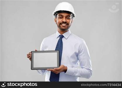 architecture, technology, construction business and building - smiling indian architect or businessman in helmet with tablet computer over grey background. architect or businessman in helmet with tablet pc