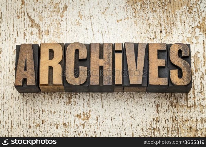 archives word in vintage letterpress wood type on a grunge painted barn wood background