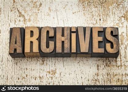 archives word in vintage letterpress wood type on a grunge painted barn wood background