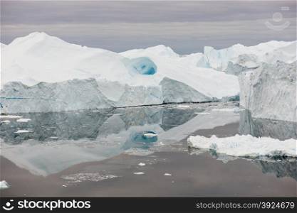 Arctic landscape in Greenland around Disko Island with icebergs, ocean, and cloudscape