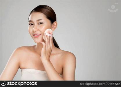 Ardent woman applying her cheek with dry powder and looking at camera. Portrait of younger with perfect makeup and healthy skin concept.. Ardent woman applying her cheek with dry powder while looking at camera.