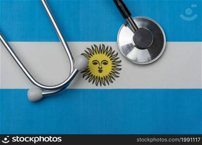 Argentina flag and stethoscope. The concept of medicine. Stethoscope on the flag as a background.. Argentina flag and stethoscope. The concept of medicine.