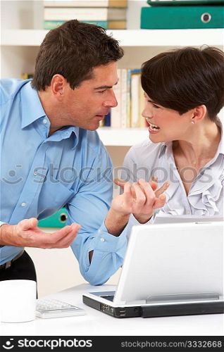 Arguing Couple Working From Home Using Laptop