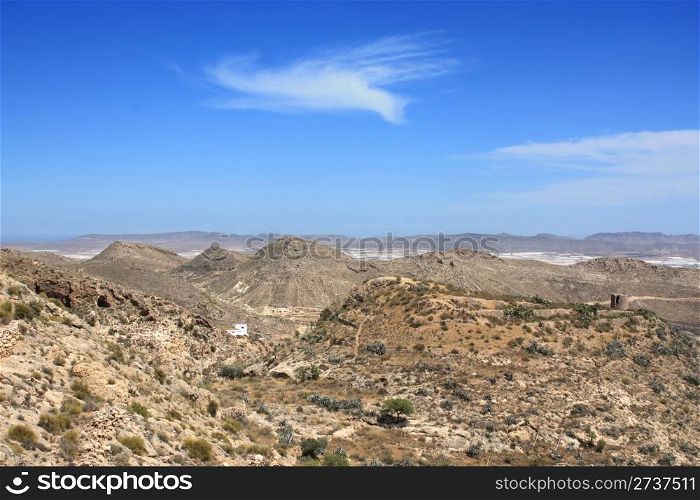 Arid landscape in Nijar, with white greenhouses in the background. Province of Almeria, Andalusia, Spain.