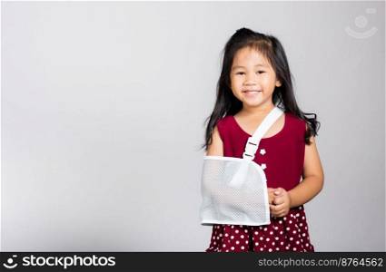 Arm broken. Litt≤cute kid girl 3-4 years old hand bo≠broken from accident with arm spl∫in studio shot isolated on white background, Asianχldren preschool injured after accident, hea<h concept