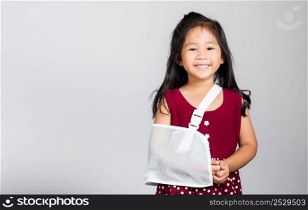 Arm broken. Little cute kid girl 3-4 years old hand bone broken from accident with arm splint in studio shot isolated on white background, Asian children preschool injured after accident, health concept