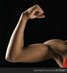 Arm of African American woman flexing muscular bicep.