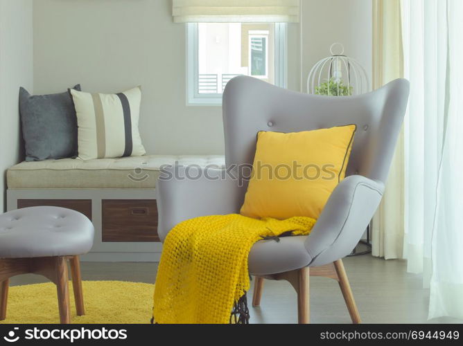 Armchair and yellow pillow and scarf in modern style living corner