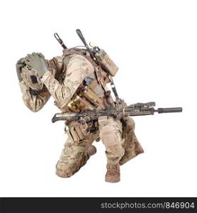 Armed infantryman in camo uniform and helmet embracing head with hands, covering himself from grenade, mine or air bomb explosion, artillery strike danger studio shoot isolated on white background. Infantryman hiding from explosion studio shoot isolated on white