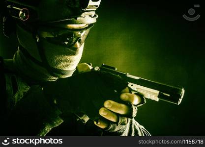 Army counter-terrorism squad, police SWAT team fighter hiding identity behind mask and glasses, wearing helmet with night vision-device, creeping in darkness, aiming service pistol during mission. Police SWAT team fighter aiming service pistol