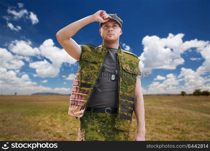 army, national service and people concept - young soldier or ranger wearing military uniform over natural background and blue sky. soldier in military uniform over sky background