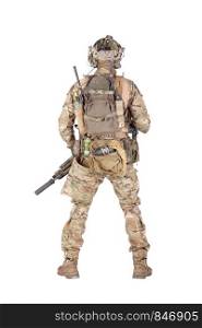 Army soldier in camo uniform and battle helmet, equipped tactical radio station with headset, wearing backpack, carrying ammo, rope, grenades in waist pouch, standing backwards isolated studio shoot. Armed army soldier standing backwards studio shoot