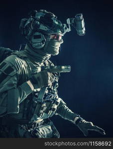 Army special operations soldier, security service fighter, commando shooter equipped modern ammunition, wearing combat helmet, mask and glasses, carefully sneaking in darkness with handgun in hand. Military security service fighter sneaking in dark