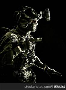 Army special operations soldier, security service fighter, commando shooter equipped modern ammunition, wearing combat helmet, mask and glasses, carefully sneaking in darkness with handgun in hand. Military security service fighter sneaking in dark
